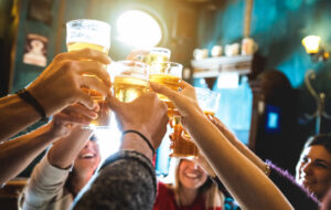 groupe d'amis portant un toast avec des verres à bière dans une brasserie locale